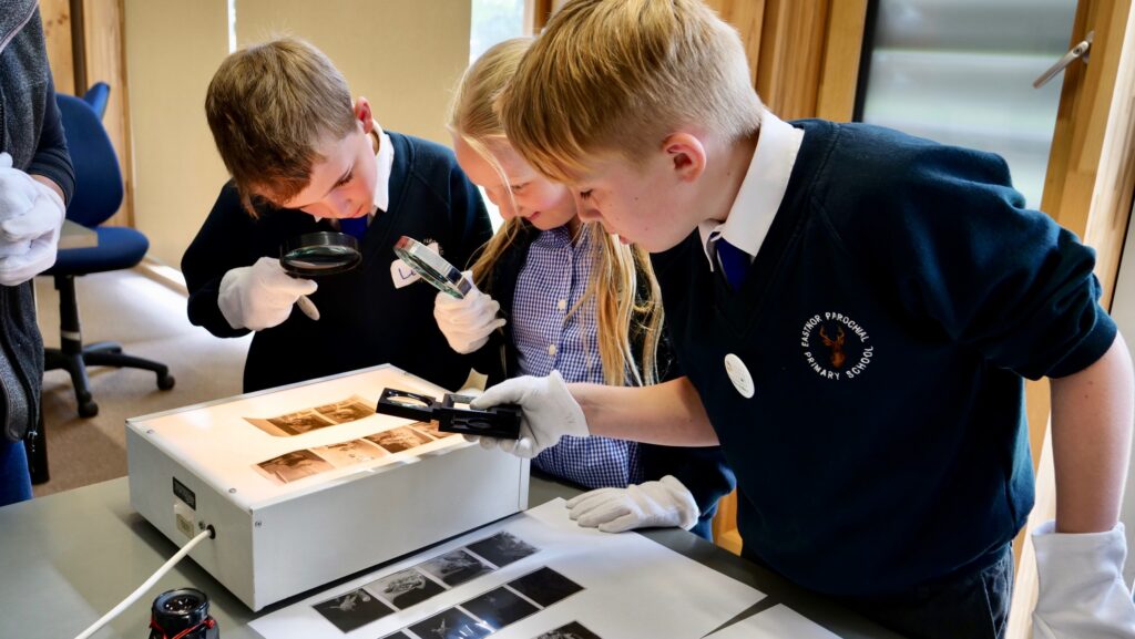 1568126148-School children look at Derek Evans original negatives at HARC, Rotherwas